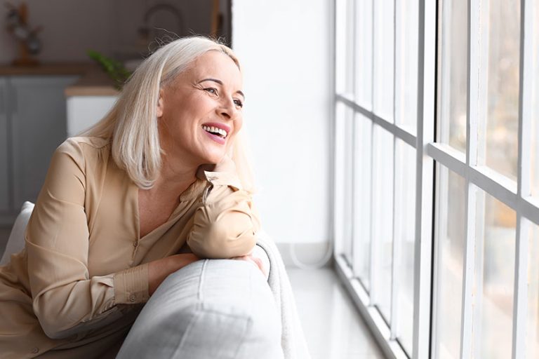 Morning of beautiful mature woman sitting on sofa Morning of beautiful mature woman sitting on sofa