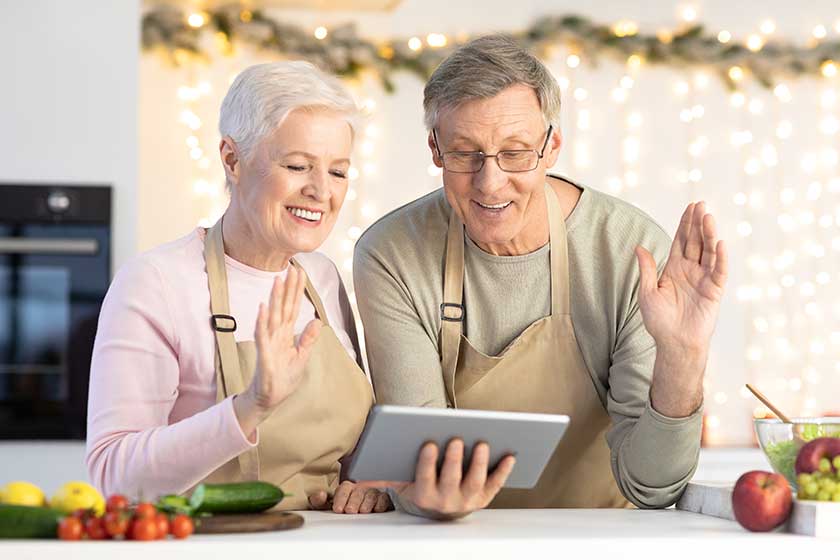 Senior Couple Waving Hello To Tablet Making Video Call Senior Couple Waving Hello To Tablet Making Video Call