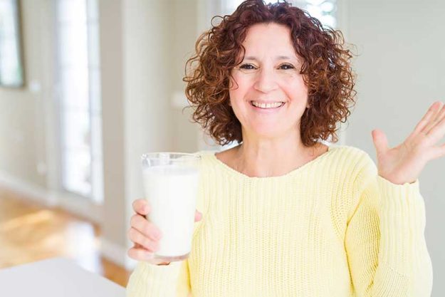 Senior woman drinking a glass of fresh milk