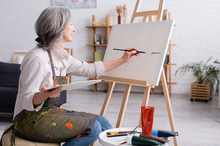 Cheerful middle aged woman holding paintbrush Cheerful middle aged woman holding paintbrush