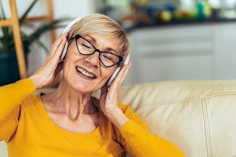 Happy elderly female in headphones