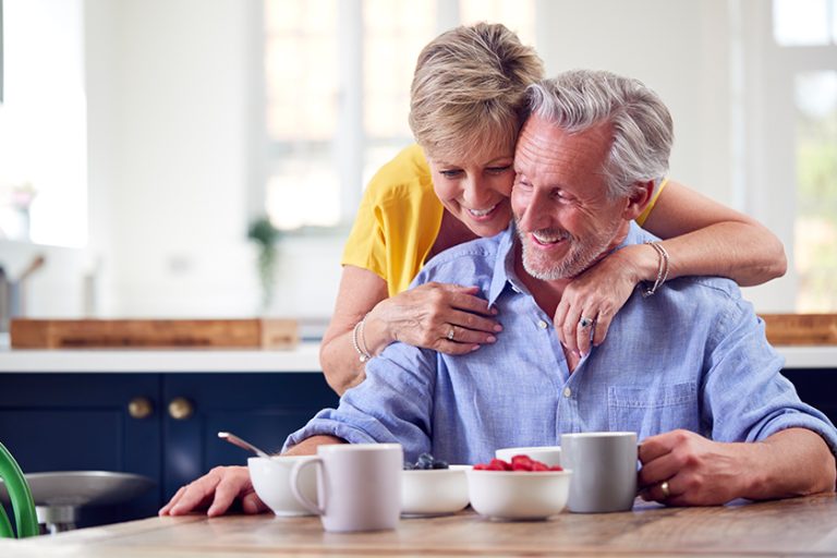 Loving Retired Couple Sitting Around Table Loving Retired Couple Sitting Around Table