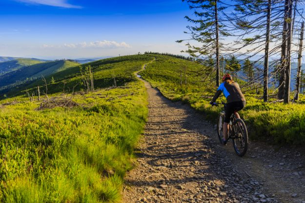 Mountain biking women riding on bike in early spring mountains f Uncovering The Beautiful Bike Trails Around Senior Homes In Wernersville, PA