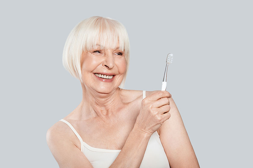 Smiling senior woman holding toothbrush
