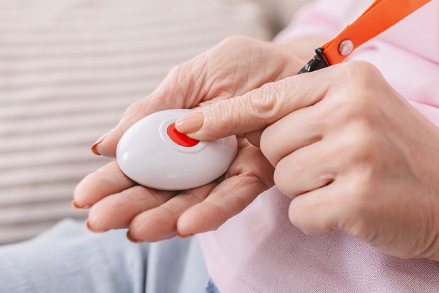 Senior woman hand pressing Alarm Button,