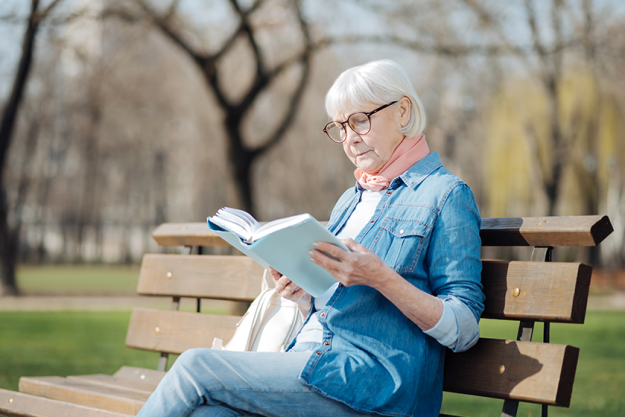 Concentrated old woman reading a book Concentrated old woman reading a book