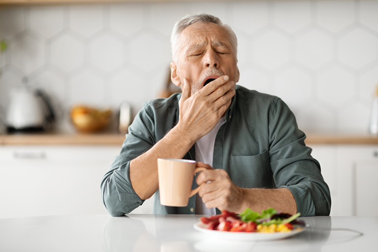 Tired Senior Man Yawning At Table Tired Senior Man Yawning At Table