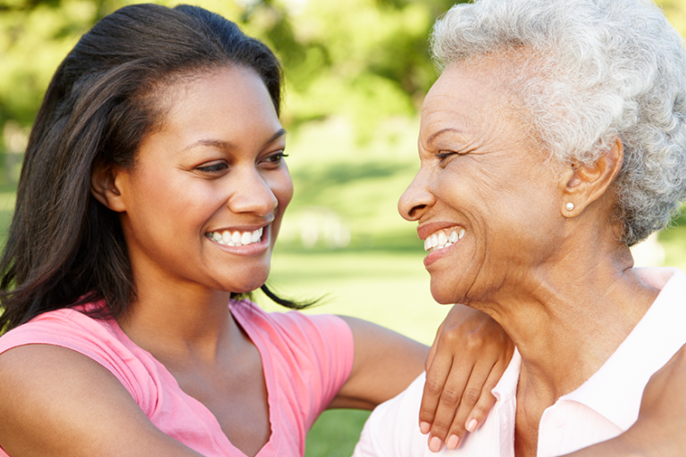 Mother And Adult Daughter Relaxing In Park