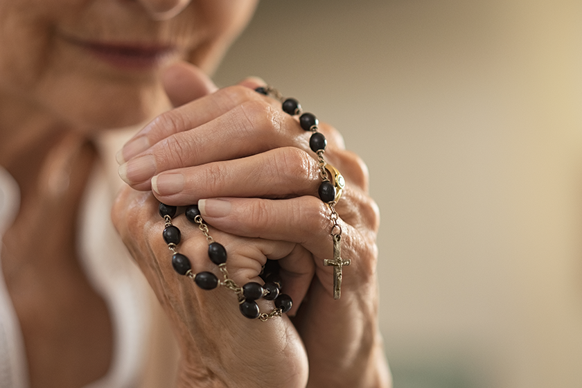 Old wrinkled hands holding a rosary Old wrinkled hands holding a rosary