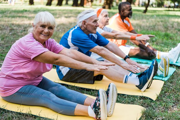 Selective focus of happy senior woman in sportswear exercising