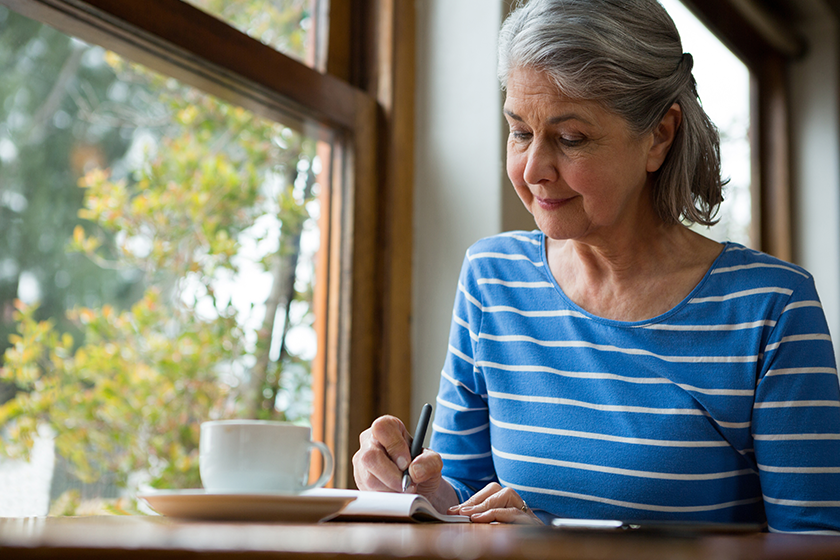 Senior woman writing in a diary Senior woman writing in a diary