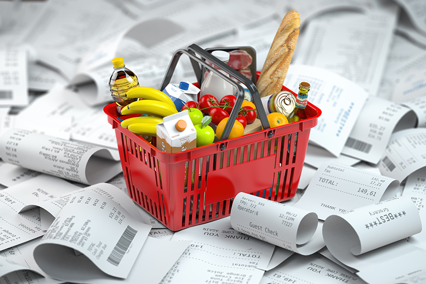 Shopping basket with foods on the pile of receipt