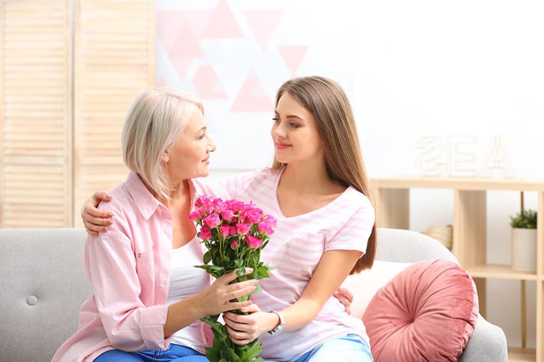 Young daughter congratulating her mature mother at Young daughter congratulating her mature mother at