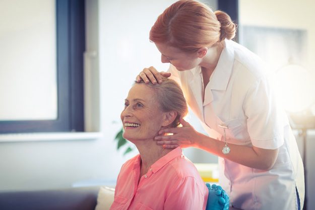 Female nurse giving head massage to woman Female nurse giving head massage to woman