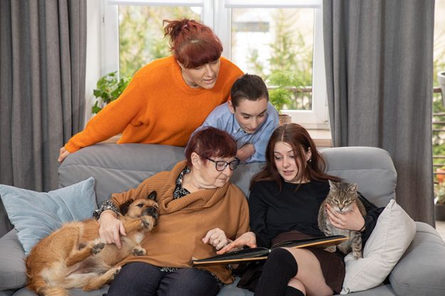 Family is looking at photo book in the living room Family is looking at photo book in the living room
