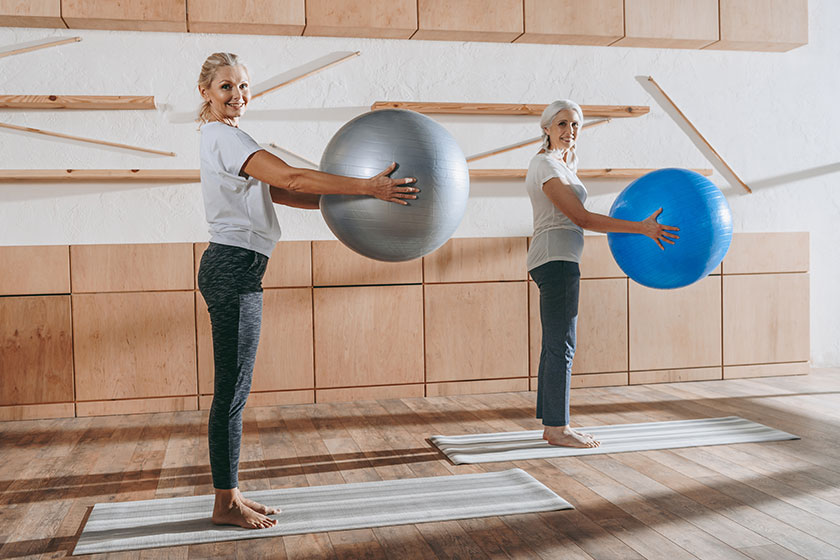 Group of senior women people exercising with fitness balls in studio