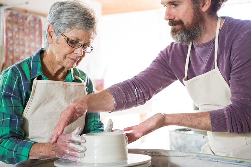 Male potter assisting female potter Male potter assisting female potter