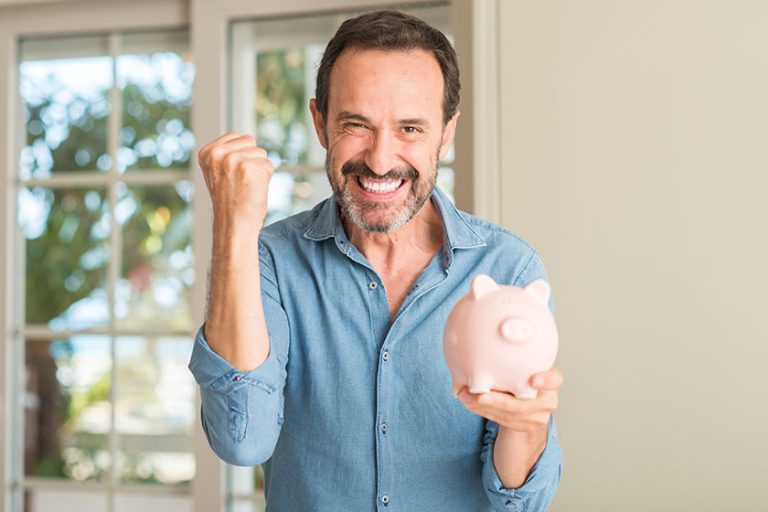 Middle age man save money on piggy bank screaming proud celebrating victory