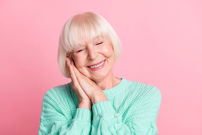 Photo portrait of overjoyed old lady keeping hands together smiling