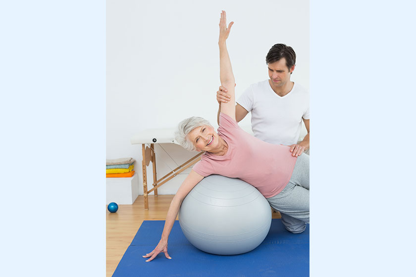 Physical therapist assisting senior woman