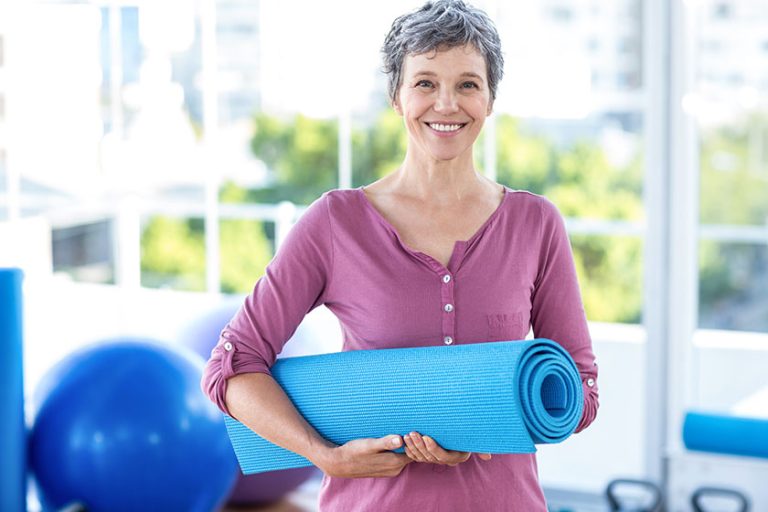 Portrait of mature woman with yoga mat Portrait of mature woman with yoga mat