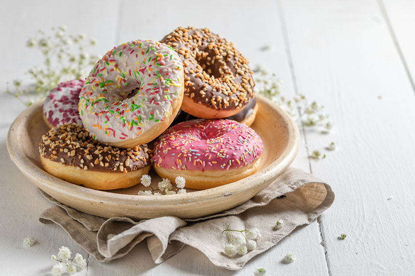 Yummy and fresh donuts on white wooden table