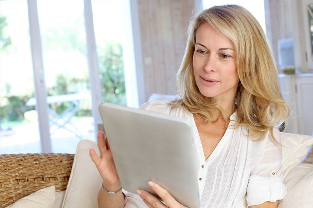 Beautiful mature woman using electronic tablet