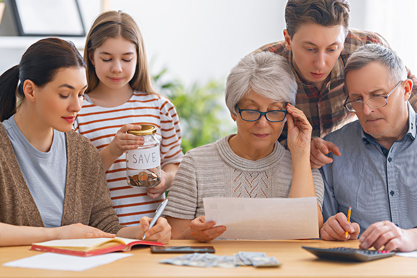 family-sitting-desk-paper-receipt-calculating-expenses-managing-budget Family are sitting at a desk with a paper receipt an