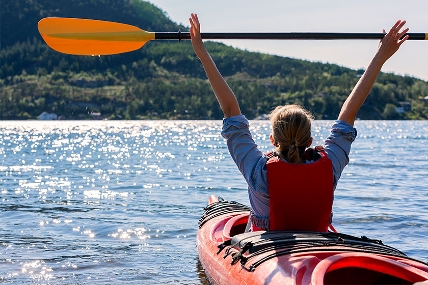 The girl holds a paddle over her head and floats The girl holds a paddle over her head and floats