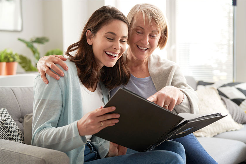 Happy mother and adult daughter looking photo album Happy mother and adult daughter looking photo album