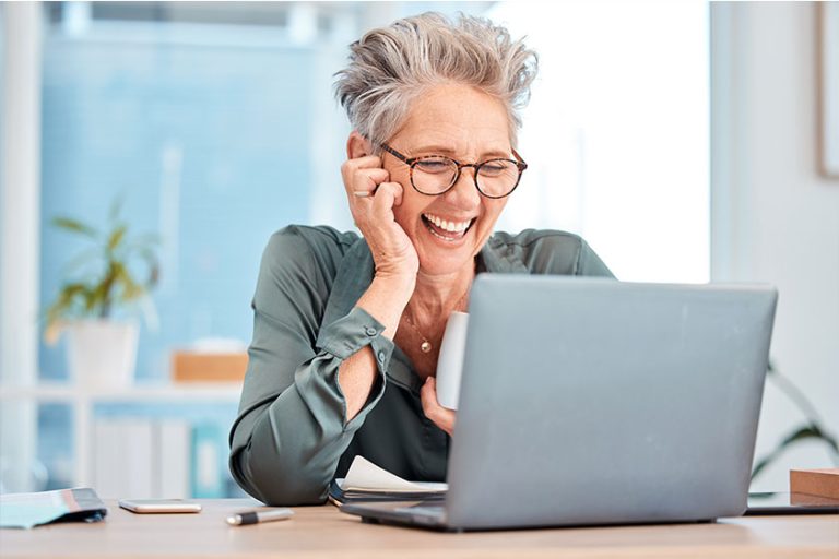 Laptop, coffee and senior business woman laughing Laptop, coffee and senior business woman laughing