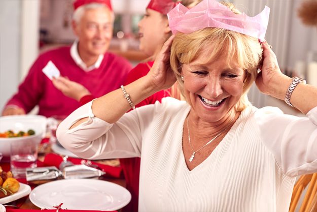 Multi Generation Family In Santa Hats Enjoying