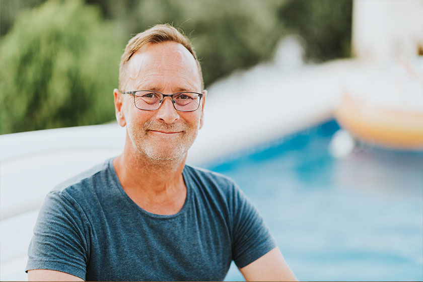 Outdoor portrait of 50 year old man resty by the pool wearing blue shirt Outdoor portrait of 50 year old man resty by the pool wearing blue shirt
