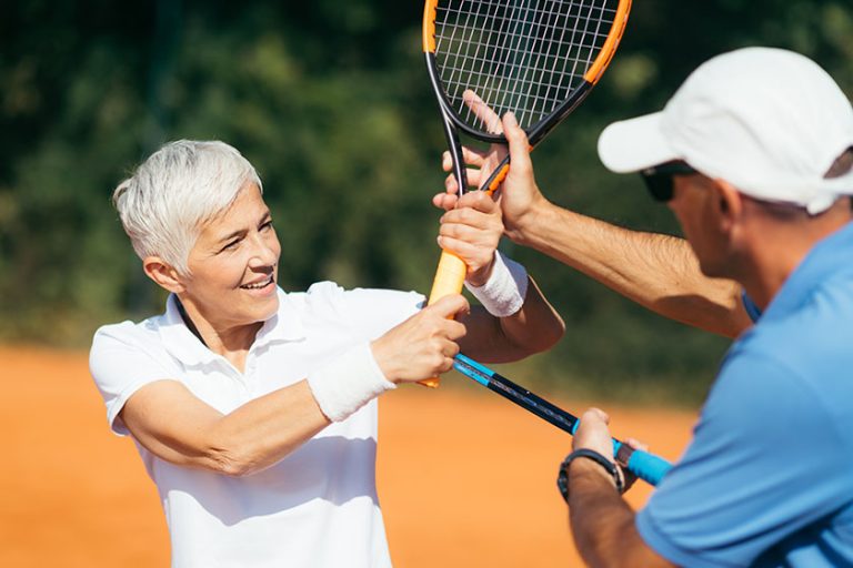 Tennis Instructor Teaching Elderly Woman Tennis Instructor Teaching Elderly Woman