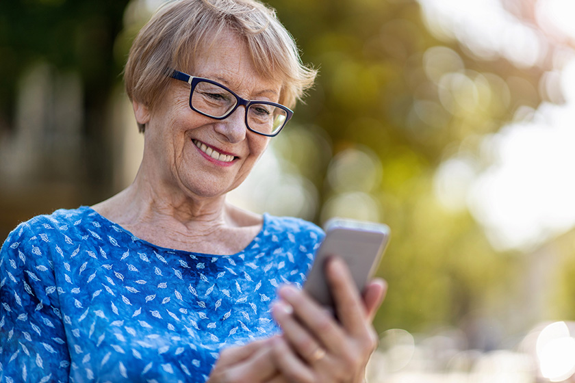 Happy senior woman using mobile phone outdoors Happy senior woman using mobile phone outdoors