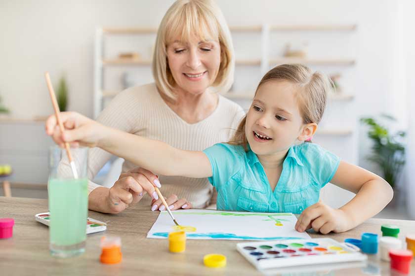 Portrait granny and granddaughter drawing with paint at home Portrait granny and granddaughter drawing with paint at home