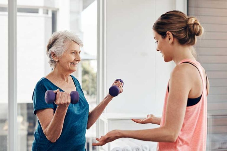 Putting in some muscle-strengthening moves. a fitness instructor helping a senior woman with some weightlifting exercises