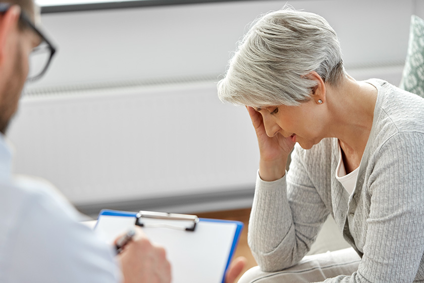 Sad senior woman patient and psychologist