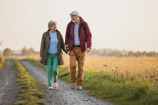 Senior couple in a field in autumn at sunset Senior couple in a field in autumn at sunset