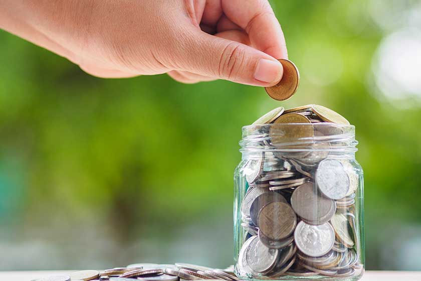 Woman hand putting money coin into glass jar for saving money. saving money and financial concept Woman hand putting money coin into glass jar for saving money. saving money and financial concept