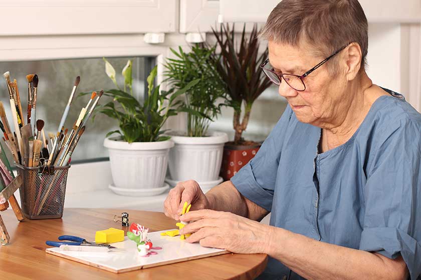 Active old age. An elderly woman sculpts small toys from polymer clay. Art therapy. the age of 80 years. A happy elderly person is engaged in creativity Active old age. An elderly woman sculpts small toys from polymer clay. Art therapy. the age of 80 years. A happy elderly person is engaged in creativity