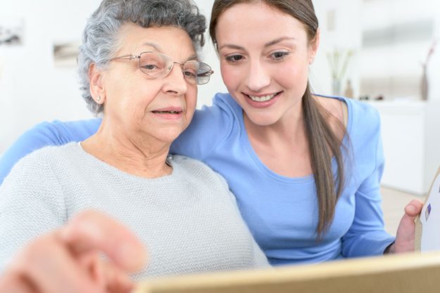 Granddaughter showing old lady how to use tablet