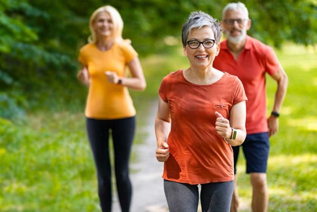 Group of active senior people running together outdoors