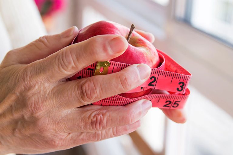 Hands with apples and tape measure, concept of diet and weight control.