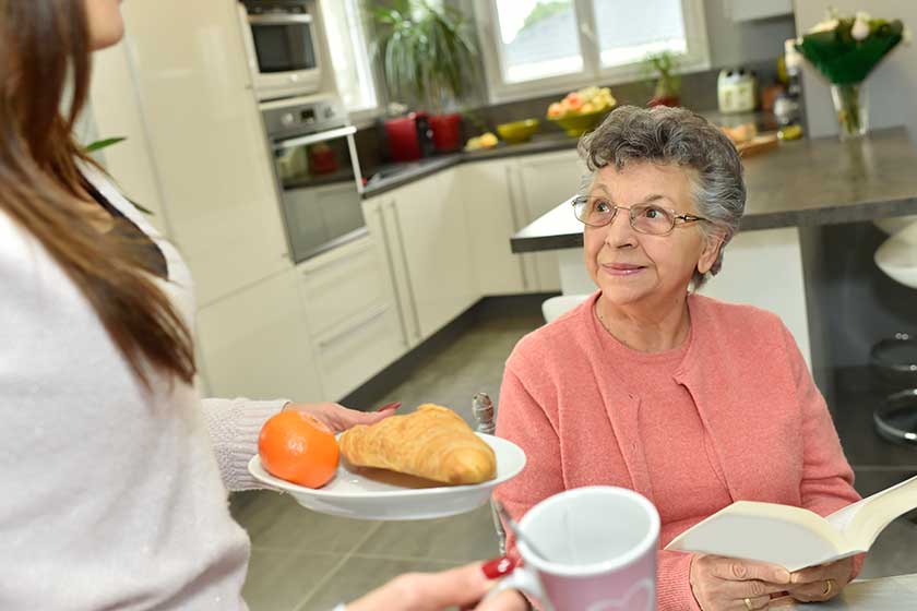 Home helper serving breakfast Home helper serving breakfast