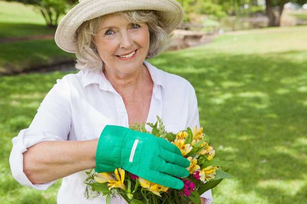 Mature woman holding plant Mature woman holding plant