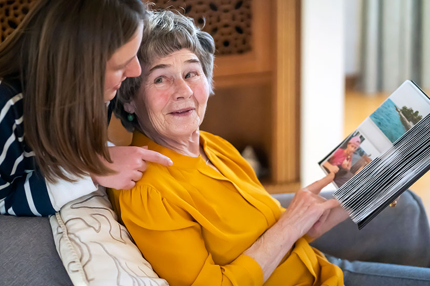 Old woman with her granddaughter look at family photos.