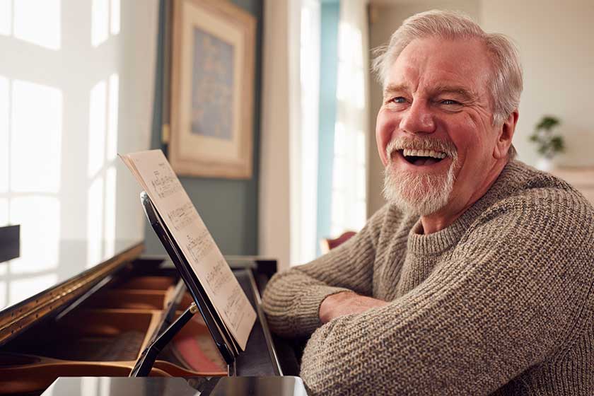 Portrait Of Senior Man At Home Enjoying Learning To Play Piano Portrait Of Senior Man At Home Enjoying Learning To Play Piano