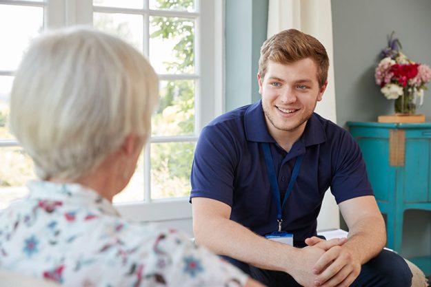 Senior woman talking with male care worker on home Senior woman talking with male care worker on home
