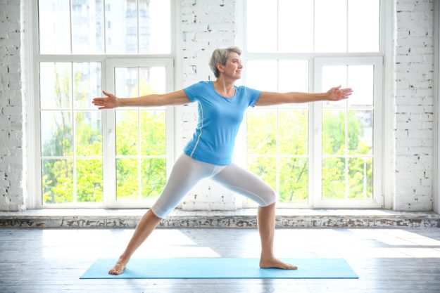 Sporty mature woman practicing yoga at home Sporty mature woman practicing yoga at home